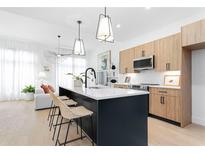 Modern kitchen features an island with seating and contemporary pendant lighting at 567 Ponce De Leon Ne Ave # 614, Atlanta, GA 30308