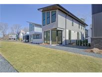 Modern two-story home featuring large windows, sleek design, and well-manicured lawn at 115 Arcadia Ave, Fayetteville, GA 30214