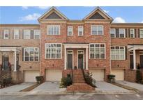 Charming brick townhouse featuring a private garage and entryway with decorative staircase at 1690 Mosaic Way, Smyrna, GA 30080