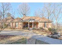 Charming brick home featuring a well-manicured front lawn, walkway, and an inviting front porch at 8720 Rhapsody Ln, Cumming, GA 30041