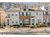 Charming townhome with a mix of brick and siding, complemented by well-maintained landscaping and ample parking spaces at 1331 Penhurst Dr, Lawrenceville, GA 30043