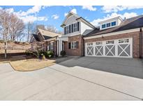 Charming brick home featuring a three car garage and manicured landscaping at 2752 Middlecreek Way, Cumming, GA 30041