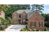 Beautiful two-story brick home with manicured lawn and mature trees in a quiet neighborhood at 1734 Doonbeg Ct, Kennesaw, GA 30152