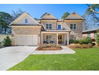 Charming brick home featuring a well-manicured lawn, a two-car garage, and a welcoming front porch at 3576 Sexton Woods Dr, Chamblee, GA 30341