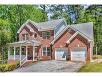 Charming two-story brick home featuring a front porch and two-car garage at 4668 Raiders Ridge Ct, Lithonia, GA 30038