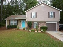 Charming two-story home with a well-manicured lawn, brick accents, and a vibrant turquoise front door at 4678 Browns Mill Ferry Rd, Lithonia, GA 30038
