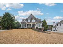 Charming two-story home featuring stone accents, a well-manicured lawn, and a welcoming front porch at 4740 Arbor Meadows Dr, Cumming, GA 30040