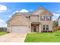 Charming two-story brick home with a well-manicured lawn and an attached two-car garage in a suburban setting at 4758 Sultana Way, Atlanta, GA 30331
