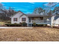 Charming home showcasing a spacious front porch, complemented by well-maintained landscaping at 218 Pine Needle Trl, Villa Rica, GA 30180