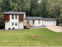 Split-level home with white siding, dark roof, attached garage and front yard at 1173 Mill Ridge Dr, Lawrenceville, GA 30045