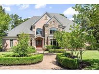 Beautiful brick and stone home showcasing manicured landscaping and a welcoming entrance at 8480 St Marlo Fairway, Duluth, GA 30097