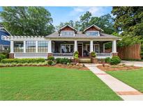 Charming home with a welcoming front porch, manicured lawn and beautiful landscaping at 1518 Cambridge Ave, Atlanta, GA 30337