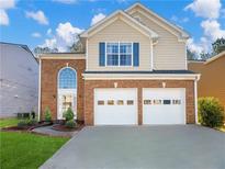 Charming two-story home with a brick facade, two-car garage, landscaped yard, and blue shutter at 2304 Stancrest Ln, Lawrenceville, GA 30044