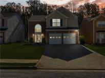 Charming two-story home with brick accents, attached two-car garage and manicured lawn at dusk at 2304 Stancrest Ln, Lawrenceville, GA 30044