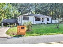 Charming single-story home featuring a large, inviting front yard, attached carport, and modern white facade at 4285 Hurt Bridge Rd, Cumming, GA 30028