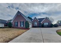 Charming brick home with a well-manicured lawn and a long driveway at 930 Rafington Dr, Lawrenceville, GA 30046