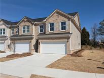 Newly constructed two-story townhome with brick facade, gray shutters and a two car garage at 960 Elwood St, Dacula, GA 30019