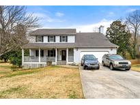 Charming two-story home featuring a welcoming front porch and attached two-car garage at 1710 Meadowchase Ct, Snellville, GA 30078