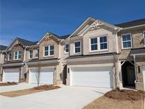 Charming brick townhomes featuring attached garages and modern architectural details at 956 Elwood St, Dacula, GA 30019