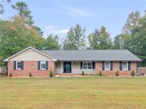 Charming brick home with a well-maintained lawn and inviting front porch at 1605 Mcgarity Rd, Mcdonough, GA 30252