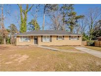 Charming single-story home featuring a welcoming front yard and long driveway at 1932 Rosewood Rd, Decatur, GA 30032