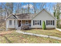 Charming home featuring stone accents, a well-maintained lawn, and mature trees at 67 Oak Landing Way, Douglasville, GA 30134