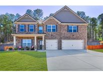Charming two-story brick home with well-manicured lawn and attached two-car garage at 2695 Ridge Manor Drive, Dacula, GA 30019