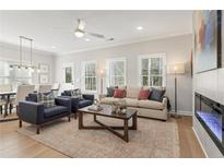 Bright living room with ceiling fan, modern fireplace, and stylish decor at 4511 Twinberry Dr, Powder Springs, GA 30127