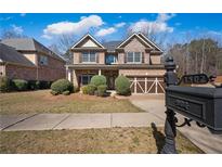 Charming two-story brick home with well-manicured landscaping and a two-car garage at 1502 Park Hollow Ln, Lawrenceville, GA 30043