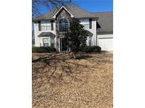 Traditional two-story home with a combination of stone and siding and a well-manicured lawn at 1546 Mine Run, Hampton, GA 30228