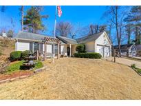 Charming single-story home featuring a well-manicured lawn, fountain and an attached two-car garage at 815 Riverstone Ln, Woodstock, GA 30188
