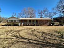 Charming brick ranch-style home with covered front porch and well-maintained lawn at 1010 Wesley Park Sw Dr, Marietta, GA 30064