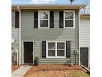 Charming townhome featuring a black door and window shutters, set against a light green facade at 4282 Worth Nw St, Acworth, GA 30101