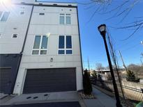 Modern townhome with gray garage door and light colored siding, complemented by large windows at 827 Winslow Nw Way, Atlanta, GA 30318
