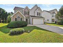 Charming two-story home featuring stone and gray siding, a two car garage, and a well maintained lawn at 2133 Creekview Trl, Decatur, GA 30035