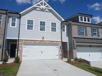 Charming townhome showcasing a brick-accented facade, attached garage, and meticulously maintained landscaping at 340 Sinclair Ct # 75, Mcdonough, GA 30253