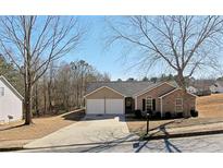 Charming single Gathering home featuring a two-car garage and well-maintained front yard with mature trees at 3577 N Winds N Trl, Douglasville, GA 30135