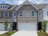 Charming townhome featuring a brick facade, pristine landscaping, and an attached two-car garage at 549 Tuskegee St # 51, Mcdonough, GA 30253
