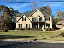 Attractive two-story brick home with well-manicured lawn and mature trees creating a warm and inviting curb appeal at 2785 Old Sewell Rd, Marietta, GA 30068