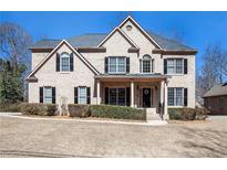 Charming two-story brick home featuring a manicured front yard, black shutters, and a covered front porch at 2785 Old Sewell Rd, Marietta, GA 30068