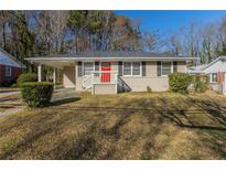 Charming ranch-style home featuring a bright red front door and a convenient covered carport at 858 Commodore Nw Dr, Atlanta, GA 30318