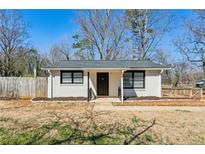 Charming single-story home featuring a white brick exterior, dark trim, and well-maintained landscaping at 105 Huskins Rd, Canton, GA 30115