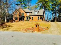 Beautiful two-story brick home with manicured lawn and mature trees at 4665 Guilford Forest Sw Dr, Atlanta, GA 30331