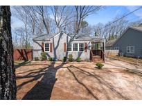 Charming home featuring a manicured lawn, inviting front porch, and freshly painted exterior at 1686 Terry Mill Se Rd, Atlanta, GA 30316