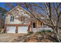 Charming home with two-car garage and inviting front porch, perfect for relaxing outdoors at 3423 Conley Downs Dr, Powder Springs, GA 30127