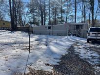 Exterior view of home with snow-covered yard and trees at 120 Valley Dr, Loganville, GA 30052