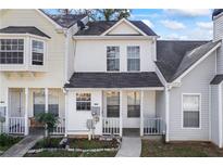Charming townhome with white siding, covered front porch, and well-manicured lawn at 5915 Trent Walk Dr, Lithonia, GA 30038