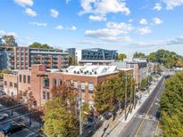 Aesthetic brick building featuring multiple stories, a flat roof, and a visible street at 650 Glen Iris Ne Dr # 15, Atlanta, GA 30308