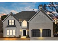 Charming two-story home with a light-colored brick exterior, black shutters, and a well-manicured lawn at 10780 S Kimball Bridge Xing, Alpharetta, GA 30022