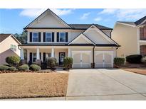 Charming two-story home with a well-manicured lawn, covered porch, and two car garage at 142 Parkway Dr, Fairburn, GA 30213